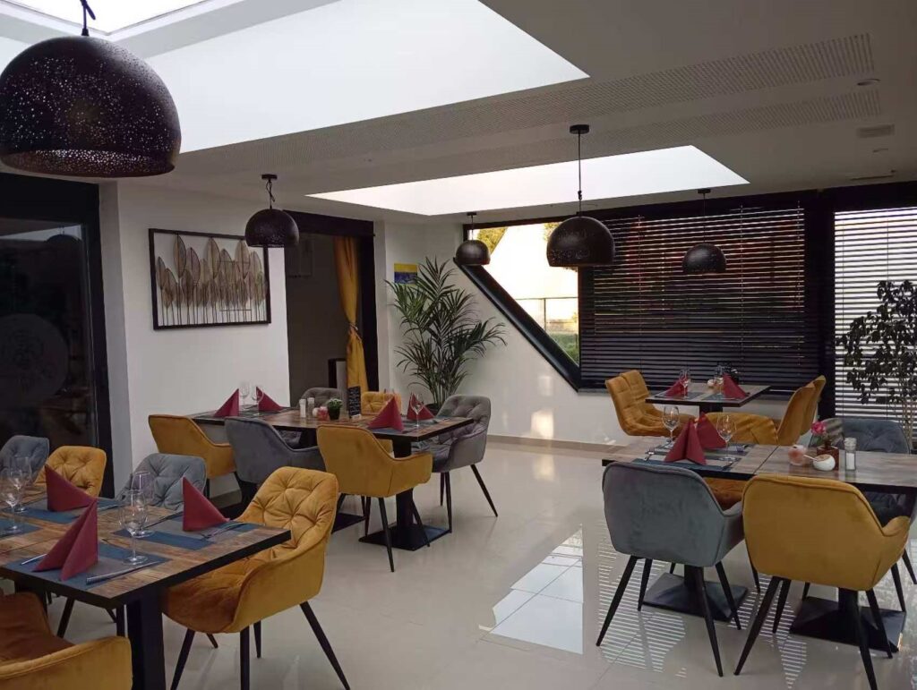 Het interieur van Lychee Garden met okergele fauteuils en gedekte tafels.