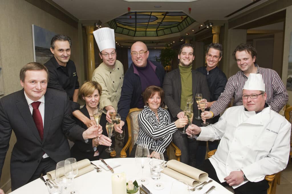 De leden van GastroRSL klinken rond de tafel, groepsfoto uit 2012.