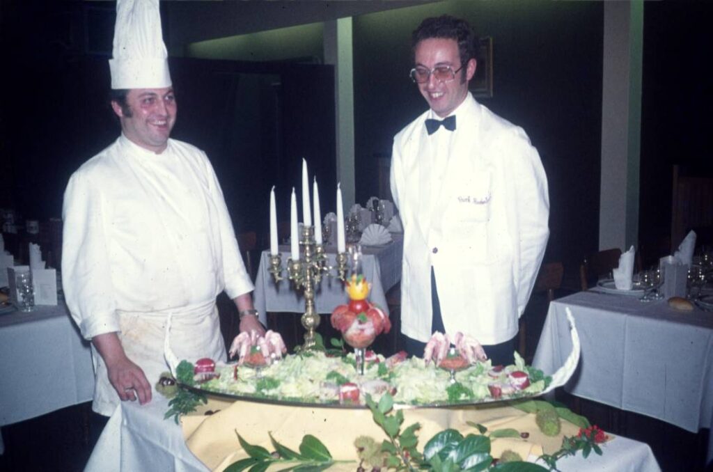 Twee koks presenteren een opgemaakte schotel, GastroRSL 1974.