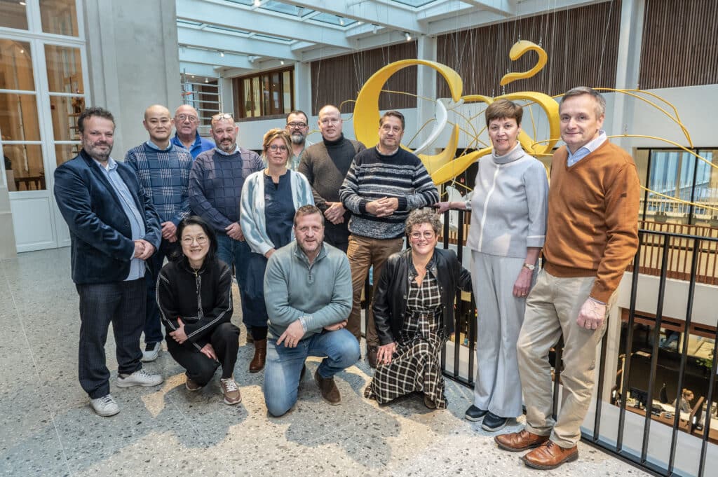 De leden van GastroRSL samen op de foto bij het gouden logo van de vereniging.