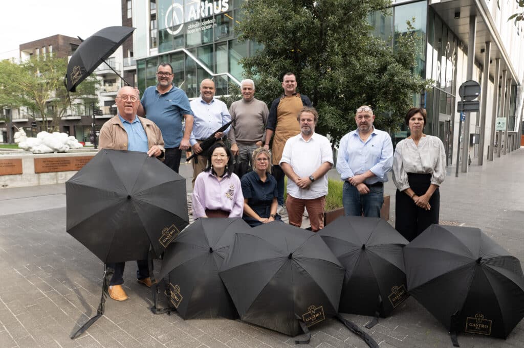 De leden van GastroRSL met paraplu's op straat in Roeselare.