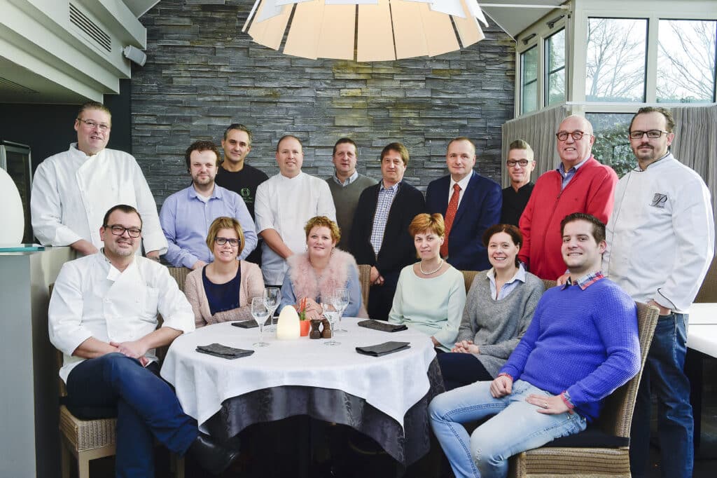 De leden van GastroRSL rond een gedekte tafel in een restaurant.