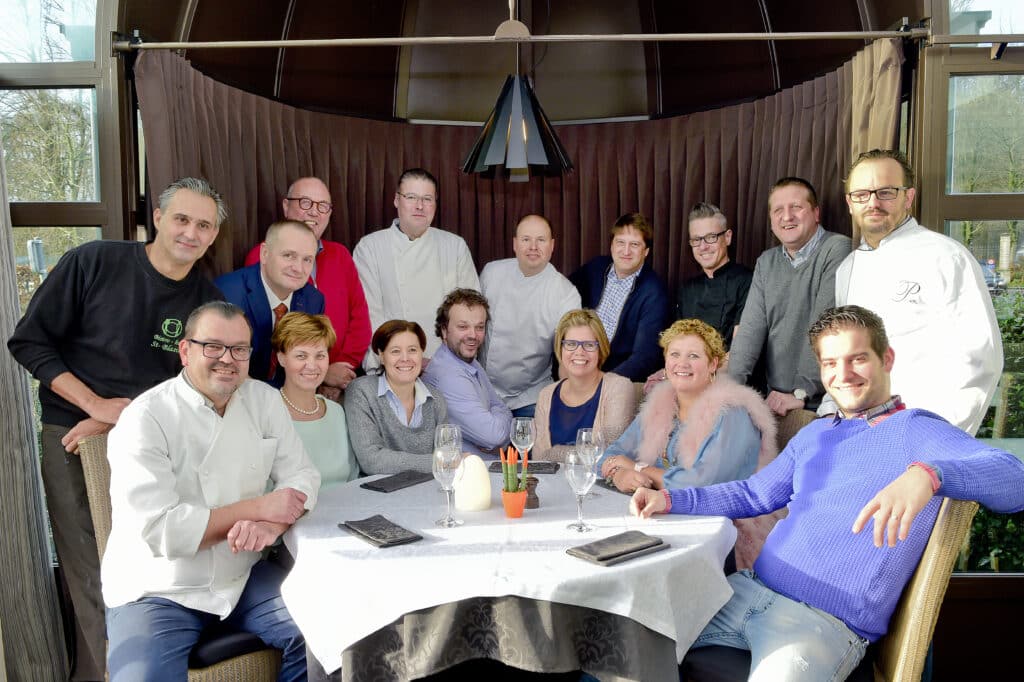 De leden van GastroRSL rond de tafel onder het houten plafond van een restaurant.